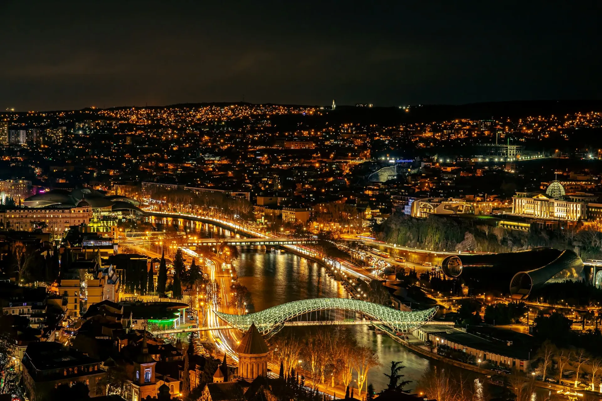 Tbilisi at night, the Mtkvari river and the Bridge of Peace seen from above